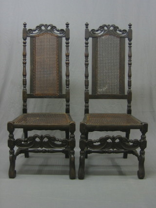 A pair of 17th Century style carved oak high back hall chairs with cane seats and backs, raised on turned and block supports