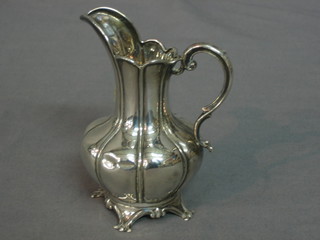 An Edwardian embossed silver cream jug raised on 4 feet, Birmingham 1909, 1oz