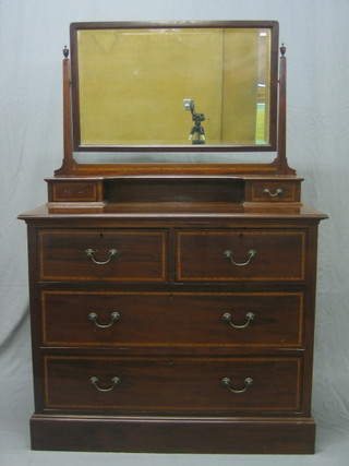 An Edwardian inlaid mahogany dressing chest fitted a rectangular bevelled plate mirror, the base fitted 2 glove drawers above 2 short and 2 long drawers raised on a platform base 39"