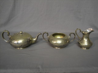 A circular silver plated 3 piece tea service with teapot, milk jug and sugar bowl