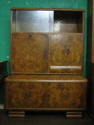 An Art Deco walnut cabinet, the upper section fitted a cupboard enclosed by glazed sliding panelled doors, the base fitted a fall front with cupboard to the side, raised on bracket feet 43"
