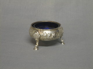 A Georgian circular embossed silver salt raised on 3 feet, complete with liner, 2 ozs, marks rubbed