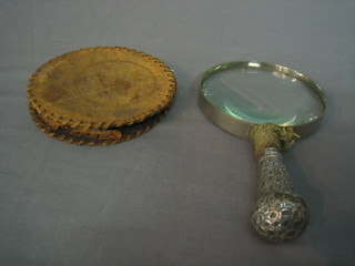 A magnifying glass with embossed silver handle