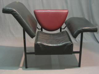 A tubular metal designed chair upholstered in black and red leather