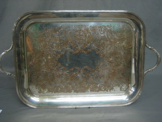 An engraved silver plated twin handled tea tray raised on 4 bun feet 20"