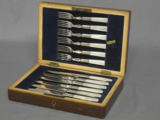 A set of 6 silver plated fruit knives with mother of pearl handles contained in a walnut canteen box