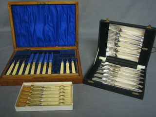 A part set of fruit knives and forks with bone handles, cased together with a set of 6 silver plated fish knives and forks cased and 6 other plated tea knives cased