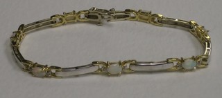 A 14ct gold bracelet set 7 oval cut opals supported by diamonds