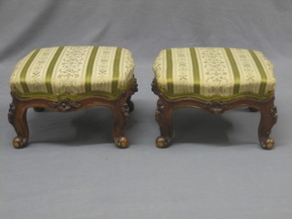 A pair of Edwardian carved showframe walnut footstools raised on cabriole supports 13"