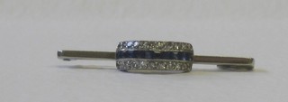 An 18ct white gold bar brooch set a row of square cut sapphires supported by diamonds