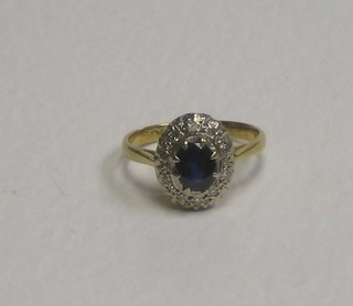 An 18ct gold dress ring set an oval cut sapphire supported by diamonds