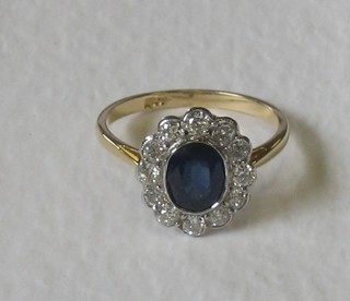 An 18ct gold dress ring set an oval cut sapphire surrounded by diamonds