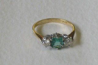 A yellow 18ct gold dress ring set a rectangular cut emerald supported by 2 diamonds (approx 0.50ct)