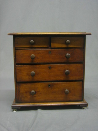 A Victorian mahogany apprentice chest of 2 short and 3 long drawers with tore handles raised on ceramics supports 14"