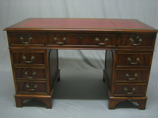 A Georgian style mahogany kneehole pedestal desk with inset tooled leather writing surface above 1 long and 8 short drawers, raised on bracket feet 48"