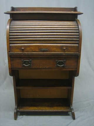 A student's oak roll top desk with three-quarter gallery with well fitted interior and tambour shutter, the base fitted a drawer above a bookcase 28"