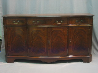 A Georgian style mahogany sideboard of serpentine outline, fitted 1 long drawer flanked by 2 short drawers with triple cupboard below, raised on bracket feet 59"