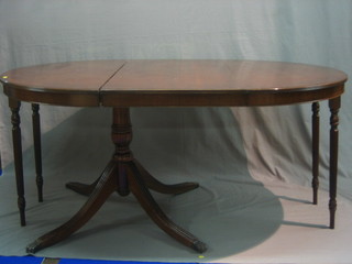 A Georgian style oval mahogany extending dining table, complete with 2 extra leaves and raised on pillar and tripod supports 42"