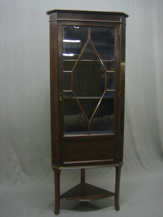 An Edwardian inlaid mahogany corner cabinet, the interior fitted shelves enclosed by an astragal glazed panelled door, the base with undertier raised on outswept supports 25"