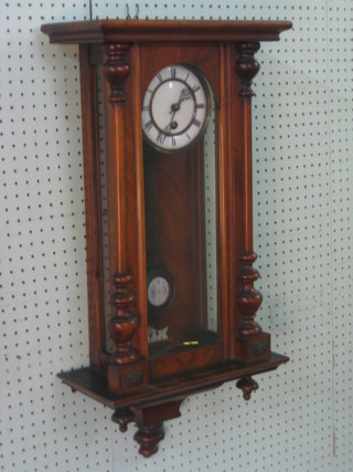 A Vienna style regulator with 5 1/2" circular dial and grid iron pendulum, contained in a walnut case