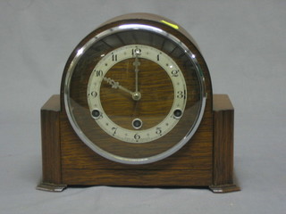 An Art Deco chiming mantel clock contained in an oak arch shaped case