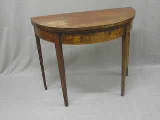 A Georgian mahogany demi lune card table raised on square tapering supports 36"