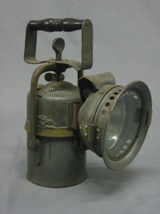 A carbide hand lantern marked The Premier Lamp