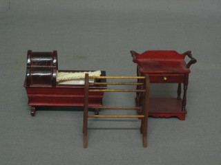 A dolls house Victorian style mahogany wash stand 2", do. towel rail 2" and a childs crib 3"