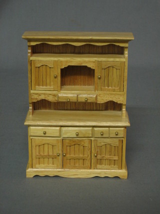 A dolls house pine dresser with raised back, fitted cupboards, drawers etc 4 1/2"