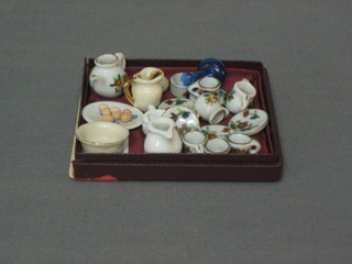 6 dolls house miniature cups and saucers, a teapot and sugar bowl, 2 jugs, a chamber pot, a bowl, a plate of eggs, a cream jug and a decanter