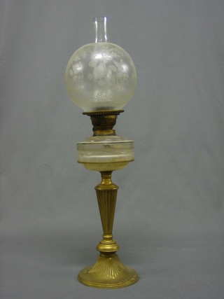 A Victorian glass oil lamp reservoir raised on a gilt painted metal stand with etched glass shade