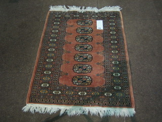 A contemporary pink ground Bokhara rug with 7 octagons 33" x 25"