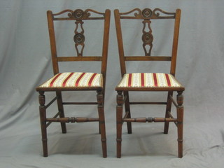 A set of 4 Edwardian pierced, slat and bar back bedroom chairs with upholstered seats, raised on turned supports 