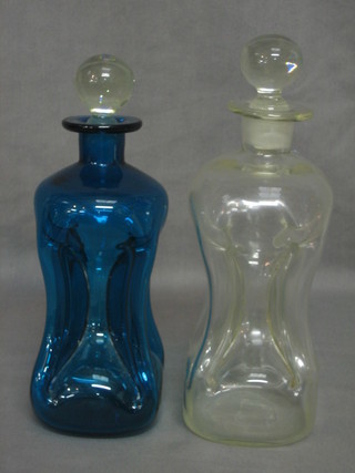 A pinched clear glass decanter and stopper and a blue glass decanter and stopper 9"