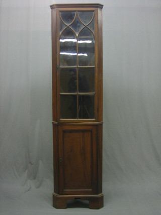 A 19th Century mahogany double corner cabinet, the interior fitted shelves enclosed by astragal glazed panelled doors, the base fitted a cupboard enclosed by a panelled door, raised on bracket feet 20"