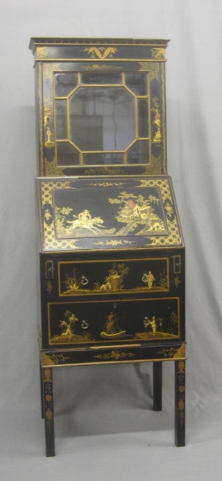 A 1930's chinoiserie style black lacquered bureau bookcase the upper section fitted a bookcase enclosed by astragal glazed panelled doors the base fitted a fall front revealing a well fitted interior above 2 long drawers, raised on square supports 21"