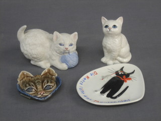A Beswick figure in the form of a seated white cat 4", an Aynsley biscuit porcelain figure of a cat 4", a Wade ashtray in the form of a cats mask 3" and a Goebel spoon rest decorated a cat