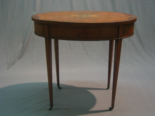 An Edwardian Sheraton style oval inlaid mahogany occasional table with ebonised stringing, raised on square tapering supports ending in brass castors 32"