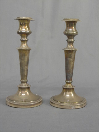 A pair of silver plated candlesticks with bead work border 12"