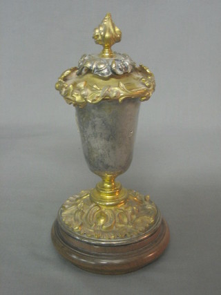 A silver plated and gilt metal goblet shaped trophy and cover, the interior with spreader and cast gilt metal decoration, raised on a circular spreading foot 9"