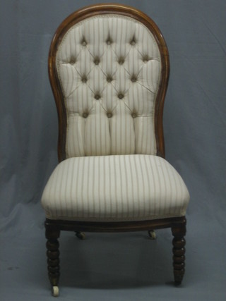 A Victorian mahogany show frame nursing chair upholstered in buttoned back striped material, on bobbin turned supports