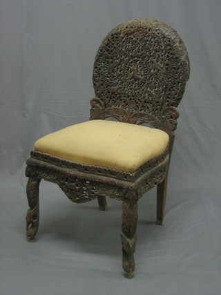 A pierced and carved Burmese hardwood chair with arch shaped back and upholstered seat, raised on cabriole supports