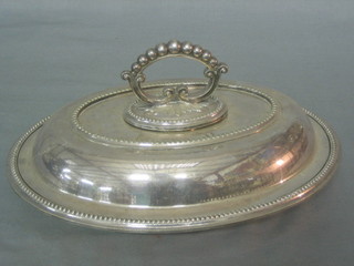 An oval silver plated entree dish and cover with bead work decoration