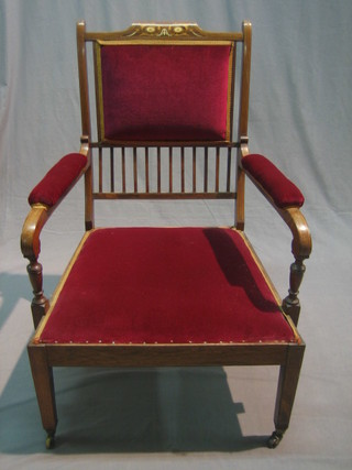 A Victorian inlaid rosewood open arm chair upholstered in red material, raised on square tapering supports