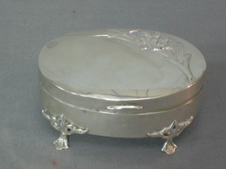 An Edwardian oval embossed silver trinket box with hinged lid decorated a flower, raised on 3 panel supports, 2 ozs