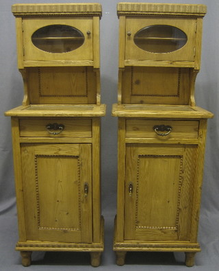 A pair of Continental pine bedside cabinets with raised back above recess, the base fitted 1 long drawer raised on turned supports 19"