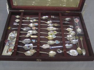 A collection of various souvenir spoons, cased