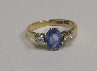 A 18ct gold dress ring set a sapphire supported by 2 diamonds