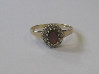 A 9ct gold dress ring set a red stone supported by white stones