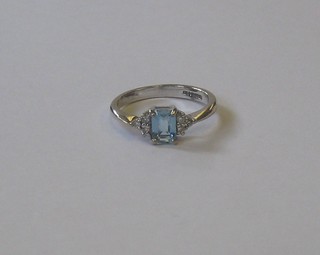 An 18ct white gold dress ring set a rectangular cut Topaz supported by diamonds